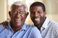 Portrait Of Smiling Senior Father Being Hugged By Adult Son At Home Royalty Free Stock Photo