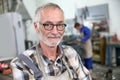 Portrait of smiling senior ironworker in workshop Royalty Free Stock Photo