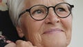 Portrait of smiling senior lady cuddling hand of a young lady on her shoulder