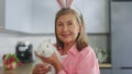 Portrait of the smiling senior lady holding the fluffy easter rabbit, wearing bunny ears. Happy elderly woman is getting