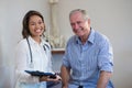 Portrait of smiling senior male patient and female therapist holding file Royalty Free Stock Photo