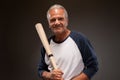 Portrait of a smiling senior man with a baseball bat