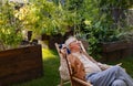 Portrait of smiling senior man resting after taking care vegetable plants in urban garden.