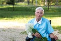 Portrait of smiling senior woman garndmother holding a purple flower pot outdoors Royalty Free Stock Photo