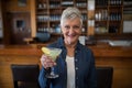 Senior woman having glass of cocktail in bar Royalty Free Stock Photo