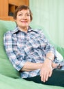 Portrait of smiling senior woman relaxing in couch Royalty Free Stock Photo