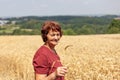 Portrait of a smiling senior woman standing in a wheat field Royalty Free Stock Photo