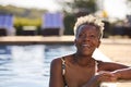 Portrait Of Smiling Senior Woman On Summer Holiday Relaxing In Swimming Pool Royalty Free Stock Photo