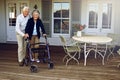 Theyll always support each other. Portrait of a smiling senior woman using a walker with her husband beside her outside Royalty Free Stock Photo