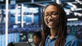 Portrait of smiling server room engineer using device to interpret AI data Royalty Free Stock Photo