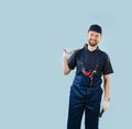 Portrait of a smiling service worker holding tools, dressed in uniform Royalty Free Stock Photo