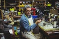 Portrait of smiling shoemaker applying glue on shoe