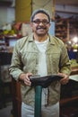 Portrait of smiling shoemaker examining a shoe