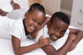 Portrait of smiling siblings lying on bed Royalty Free Stock Photo