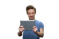 Portrait of smiling skinny guy looking at tablet pc.