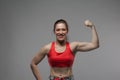 Portrait of smiling strong girl showing biceps