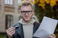 Portrait of a smiling student in casual clothes holding a pen with papers and looking straight ahead Royalty Free Stock Photo