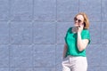 Portrait of a smiling student girl wearing sunglasses, talking on a mobile phone Royalty Free Stock Photo