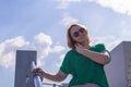 Portrait of a smiling student girl wearing sunglasses, talking on a mobile phone against the blue sky. Royalty Free Stock Photo