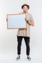 Portrait of a smiling stylish man holding blank board Royalty Free Stock Photo