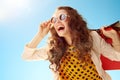 Woman looking into distance with shopping bags against blue sky Royalty Free Stock Photo