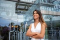 Happy businesswoman with arms crossed outside modern glass building Royalty Free Stock Photo