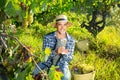 Smiling winemaker offering wine for testing in vineyard