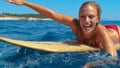 PORTRAIT: Smiling surfer girl having fun swimming to the line up to catch waves.