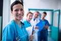 Portrait of smiling surgeon holding a clipboard in corridor Royalty Free Stock Photo