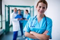 Portrait of smiling surgeon standing with arms crossed in corridor Royalty Free Stock Photo