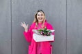 Portrait of smiling surprised blond woman, getting pink fresh bouquet of tulip flowers and present box. Delivery gift Royalty Free Stock Photo