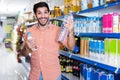 Portrait of man customer who is standing with drinks in supermarket. Royalty Free Stock Photo