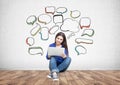 Teenage girl in jeans, laptop, speech bubbles Royalty Free Stock Photo