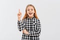 Portrait of smiling teen girl, pointing finger up, showing one, demonstrating banner, standing over white background in casual Royalty Free Stock Photo