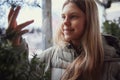 Portrait of smiling teenage girl with braces, touching touches fir branches. Blurred city background. Overcast Royalty Free Stock Photo