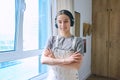 Portrait of smiling teenage girl in headphones in home room Royalty Free Stock Photo