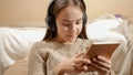 Portrait of smiling teenage girl with headphones using tablet computer and browsing internet Royalty Free Stock Photo