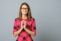 Portrait of smiling teenage girl keeps both hands together under chin feels shy Royalty Free Stock Photo