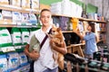 Teenager with puppy buying dry feed