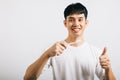 Smiling Asian young man demonstrates proper toothbrushing and approval for