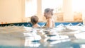 Portrait of happy smiling toddler boy learning swimming with mother in pool. Family having fun and relaxing in swimming Royalty Free Stock Photo