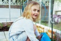 Portrait of smiling toothless little blonde girl watering vegetables in the greenhouse. Kid helping to take care of plants. Grow Royalty Free Stock Photo