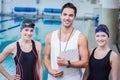 Portrait of smiling trainer and swimmers