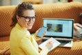 Smiling trendy woman with laptop and smartphone study online