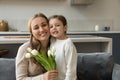 Portrait of smiling family with flowers posing at home. Royalty Free Stock Photo