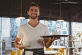 Portrait of smiling waiter holding tray Royalty Free Stock Photo