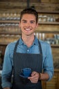 Portrait of smiling waiter serving cup of coffee Royalty Free Stock Photo