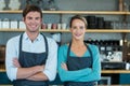 Portrait of smiling waiter and waitress standing with arms crossed Royalty Free Stock Photo
