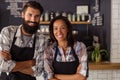 Portrait of smiling waiter and waitress standing with arms crossed Royalty Free Stock Photo