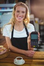 Portrait of smiling waitress holding credit card reader Royalty Free Stock Photo